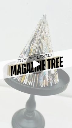 a magazine tree sitting on top of a black stand with the words diy folded magazine tree