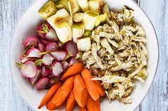 a white plate topped with carrots, celery and chicken next to sliced onions