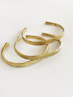 Beautiful engraved brass cuffs with round sculpted ends. There are 2 different styles of this cuff available, select the one that speaks to you. Details: Solid Brass Cuff Fits 6-7 wrist size. Can be worn daily, will require occasional polishing. Ships with polishing cloth.Packaged for gift giving. *Available in single, set of 3,5, or 9. Stack Bracelets, Bracelets Adjustable, Engraved Cuff, Bangles Gold, Brass Bangle, Brass Cuff, Egyptian Jewelry, Gold Bracelets, African Jewelry