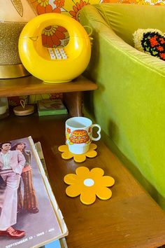 a coffee table with magazines and a magazine on it next to a couch covered in flowers