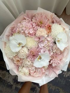 a woman holding a bouquet of pink and white flowers