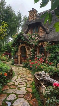 a stone path leading to a small house with flowers growing on the roof and windows