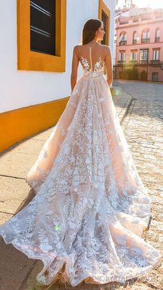 a woman in a wedding dress is walking down the street with her back to the camera