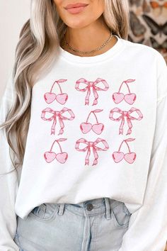 CHERRY RIBBON BOW VALENTINES GRAPHIC SWEATSHIRTPREMIUM COTTONUNISEX SIZINGCLASSIC FITMade In: USA White Printed Sweatshirt For Spring, Casual Long Sleeve Top With Cherry Print, Spring White Printed Sweatshirt, Bow Graphic, Bow Side Sweatshirt, Summer Crew Neck T-shirt With Bow Print, Casual Crew Neck T-shirt With Bow Print, Cute Cotton T-shirt With Bow Print, Pink Sand