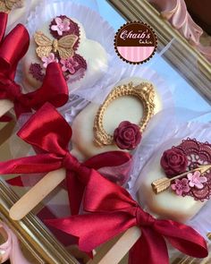 there are some cake pops that have been decorated with flowers and ribbons on them,