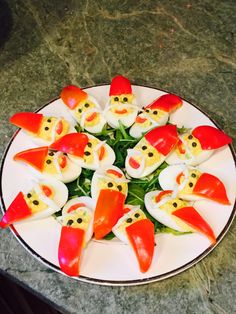 a white plate topped with red peppers and devil's head cut into small faces