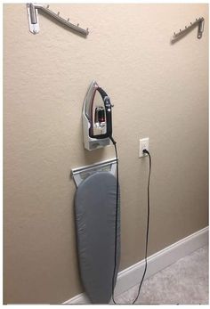 an ironing board is plugged into the wall next to a hair dryer