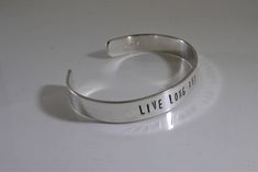 "For all the Trekkies out there! This bracelet is hand stamped with one of the most famous quotes. It says \"Live long and prosper.\" Have a different favorite quote?? You can make your own custom cuff here https://www.etsy.com/listing/157140397/custom-personalized-bracelet-38-1-line?ref=shop_home_active Shown in sterling silver but also available in the metal of your choice from the last photo. Solid gold options also available. Message me for pricing. Measures 3/8\" x 6\" and will fit most wri Inspirational Stamped Bangle Cuff Bracelet, Minimalist Stamped Adjustable Cuff Bracelet, Adjustable Stamped Minimalist Cuff Bracelet, Everyday Hand Stamped Cuff Bangle, Everyday Hand Stamped Cuff Bangle Bracelet, Hand Stamped Bangle Cuff Bracelet, Everyday Hand Stamped Bangle Cuff Bracelet, Silver Inspirational Cuff Bracelet, Inspirational Silver Cuff Bracelet