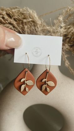 a pair of earrings with leaves on them