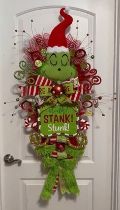 the grinch door hanger is decorated with red and green ribbons