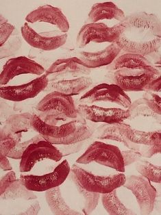 a bunch of red lipstick kisses on a white paper background with the word love written in it