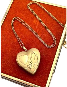 "Description: Feminine and classic vintage 14k gold filled heart shaped locket on a fine chain. The heart shaped locket pendant has an etched heart on the front left with some etched leaves on the right. The interior of the locket is completely empty and can hold two tiny photos (one on each side).  No frames remain. The back of this little locket has a shiny finish.  It closes securely with a snap.  The locket is attached to a vintage 18 1/2\" long gold filled chain which secures with a spring clasp. Beautiful piece of remembrance jewelry. Measures:  Chain: 18.5'' long. Locket (with bail): 7/8'' long. The locket is about 3/4'' in wide. Weighs:   3.8 grams (locket with chain) Condition: In nice vintage condition.  Some light use marks here and there. See photos for details. Locket opens an Vintage Engraved Open Heart Locket Necklace, Vintage Heart-shaped Engraved Necklaces, Brass Heart Pendant Locket Necklace With Vintage Charm, Custom Engraved Necklace, Heart-shaped Vintage Locket Necklace For Memorials, Locket Necklace Vintage, Valentine's Day Heart-shaped Locket Necklace In Antique Gold, Gold Heart Locket, Remembrance Jewelry