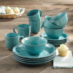 a table topped with blue dishes and cupcakes