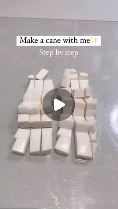 a video demonstrating how to make a cake with white icing and fondant squares