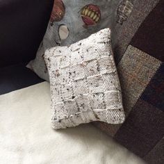 two pillows sitting on top of a couch next to each other with holes in them