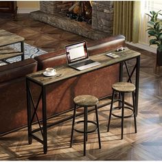 two stools and a table with a laptop on it in front of a fireplace