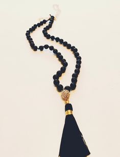 Black onyx beaded necklace knotted with silk string. A gold pave bead is attached to the black tassel and hung from the knotted black onyx beads. Beads are attached to chain at the top of the necklace. Easy to put on and off over the head as no clasp is required! Necklace hangs at approx 22". If a certain length is requested under 22" please message us, as they are made to order. For longer length, an additional charge will be added. Each piece is made by hand with love! Any questions, please message us. Pave Beads, Gemstone Beaded Necklace, Necklace Crystal, Onyx Bead, Necklace Black, Necklace Gift, Black Onyx, Gift Necklace, Long Necklace