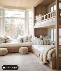 a bedroom with bunk beds and pillows on the bottom floor, along with two couches