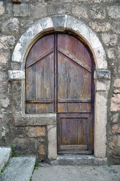 an old wooden door with stone steps leading up to it