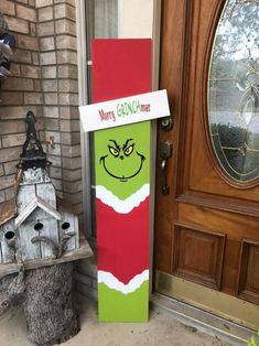 the front door of a house decorated for christmas with an elf's face painted on it