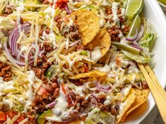 a bowl filled with taco salad and tortilla chips on top of it