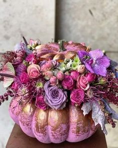 a pink pumpkin filled with lots of flowers