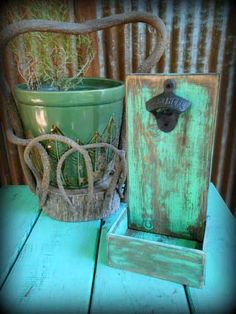 a potted plant sitting on top of a wooden table next to a green container