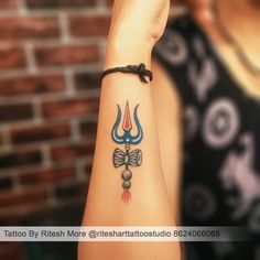 a woman with a tattoo on her arm is holding up the wrist and has a bow