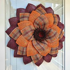 an orange and brown flower sitting on top of a window sill