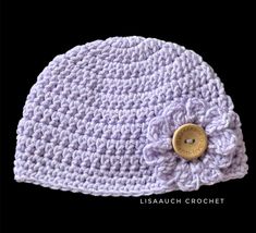 a crocheted hat with a button on the side and a flower in the middle