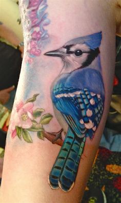 a blue jay on the arm with flowers and leaves around its neck is painted in pastel colors