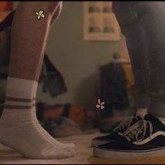 two people standing next to each other wearing black and white shoes with flowers on them