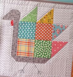 a quilted wall hanging with an image of a bird on it