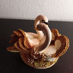 a figurine of a swan sitting on top of a table