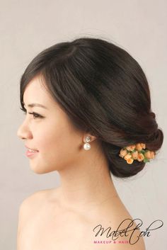 a woman with flowers in her hair wearing an orange and yellow flower clip on her head