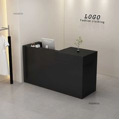 a black reception desk in front of a white wall with the name logo fashion clothing on it