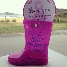 a pink boot with writing on it sitting in front of a sign that says, thank you for your generous support