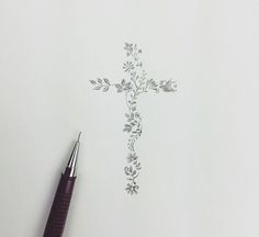 a pen sitting on top of a piece of paper with a cross drawn on it