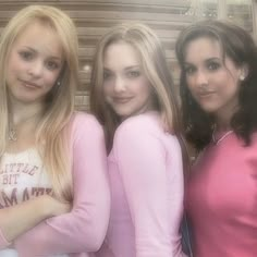 three beautiful young women standing next to each other