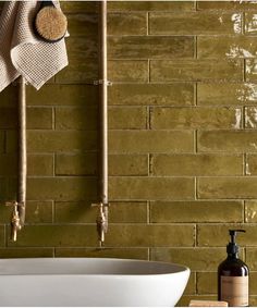 a white sink sitting next to a green brick wall