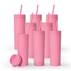 six pink tumblers with straws and lids are lined up in a row on a white background