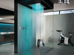 a modern bathroom with a shower, mirror and exercise bike in the corner next to it