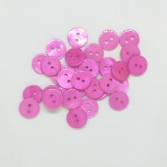 pink buttons are scattered on a white surface