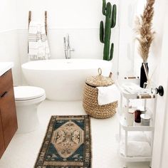 a bathroom with a rug, toilet and bathtub in the corner next to a cactus