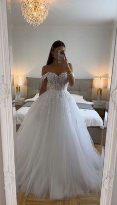 a woman taking a selfie in her wedding dress while standing in front of a mirror