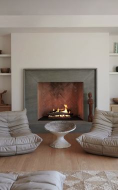 a living room with two couches and a fire place in the middle of it