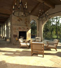 an outdoor living room with chairs and a fire place