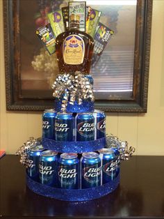 a cake made to look like a stack of soda cans with a bottle of bud light on top