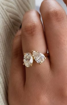 a woman's hand with three pear shaped diamond rings on top of her finger