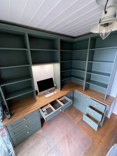 a desk with drawers and a computer on it in a room that has wooden floors